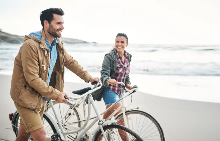 couple riding bikes on the beach for some reason